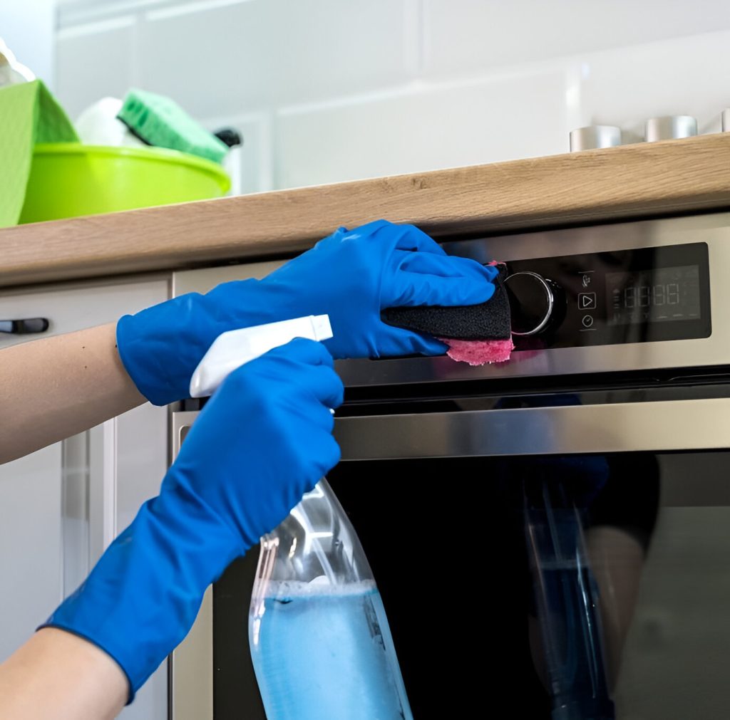 young woman cleaning oven with rubber gloves rag cleaning concept 1024x683 1